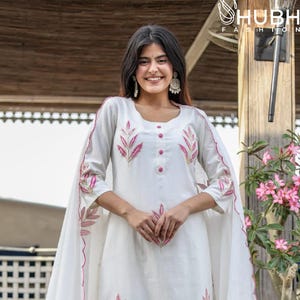 Puede incluir: Conjunto kurta blanco bordado con dupatta a juego. El kurta presenta bordados florales rosas en las mangas, el corpiño y el dobladillo. El dupatta tiene un borde festoneado con bordados a juego. El conjunto se usa con pantalones blancos.