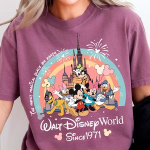 A woman wearing a purple t-shirt with a Disney World logo and text.