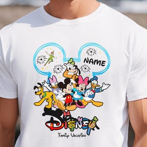 A man wearing a white t-shirt with a Disney character design printed on it.