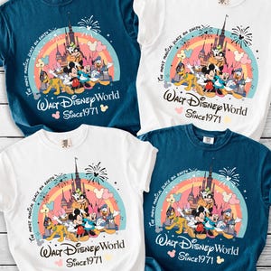 a collection of four Disney-themed t-shirts, each featuring a different design and color scheme. The t-shirts are arranged on a wooden surface, showcasing the vibrant and playful graphics of the Disney characters and landmarks.