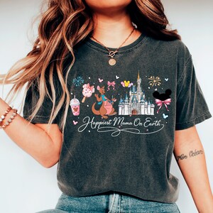 A woman wearing a black t-shirt with a Disney-themed graphic design, including a castle, kangaroo, and other Disney characters.