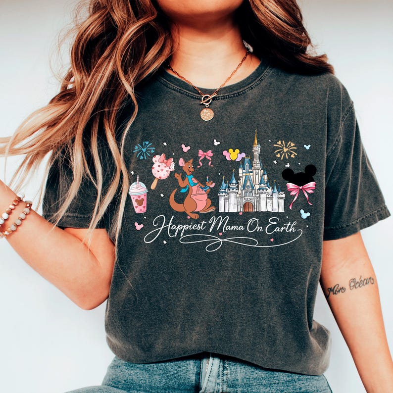 A woman wearing a black t-shirt with a Disney-themed graphic design, including a castle, kangaroo, and other Disney characters.