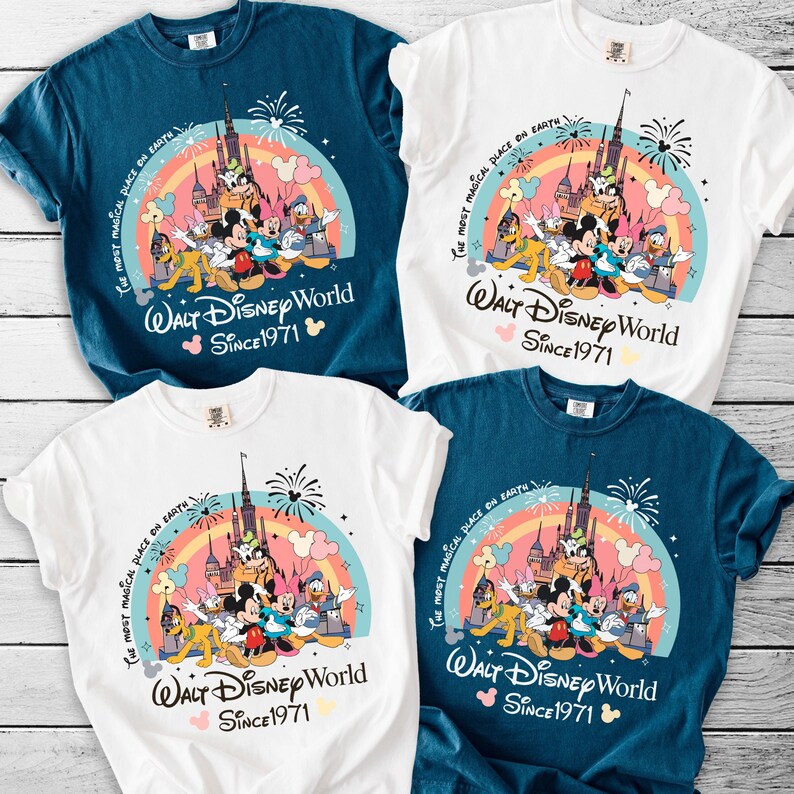 a collection of four Disney-themed t-shirts, each featuring a different design and color scheme. The t-shirts are arranged on a wooden surface, showcasing the vibrant and playful graphics of the Disney characters and landmarks.