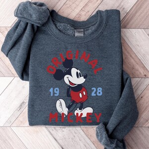 A gray sweatshirt with a graphic of Mickey Mouse printed on it.