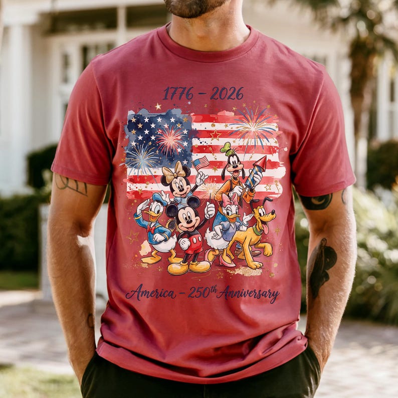 A man wearing a red t-shirt with a graphic design featuring Disney characters and fireworks, celebrating the 50th anniversary of the United States.
