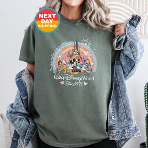 May include: Green t-shirt with a colorful graphic of Mickey Mouse and friends in front of a castle. The text "The most magical place on earth" and "Walt Disney World Since 1971" is printed on the shirt.