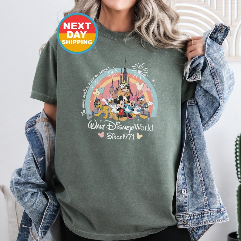May include: Green t-shirt with a colorful graphic of Mickey Mouse and friends in front of a castle. The text "The most magical place on earth" and "Walt Disney World Since 1971" is printed on the shirt.