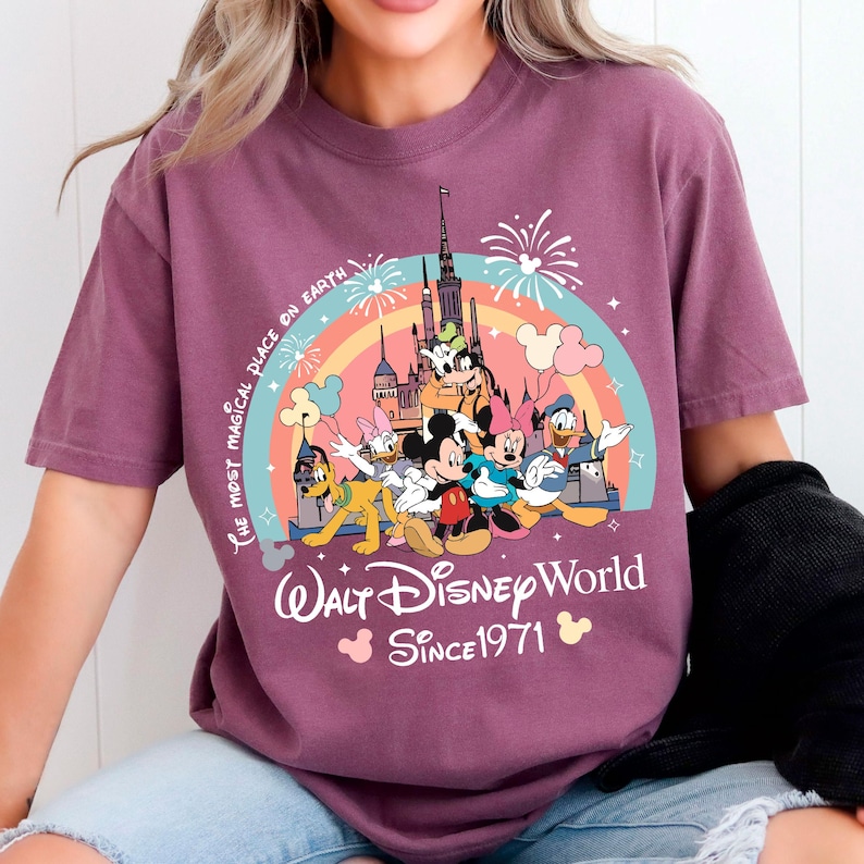 A woman wearing a purple t-shirt with a Disney World logo and text.
