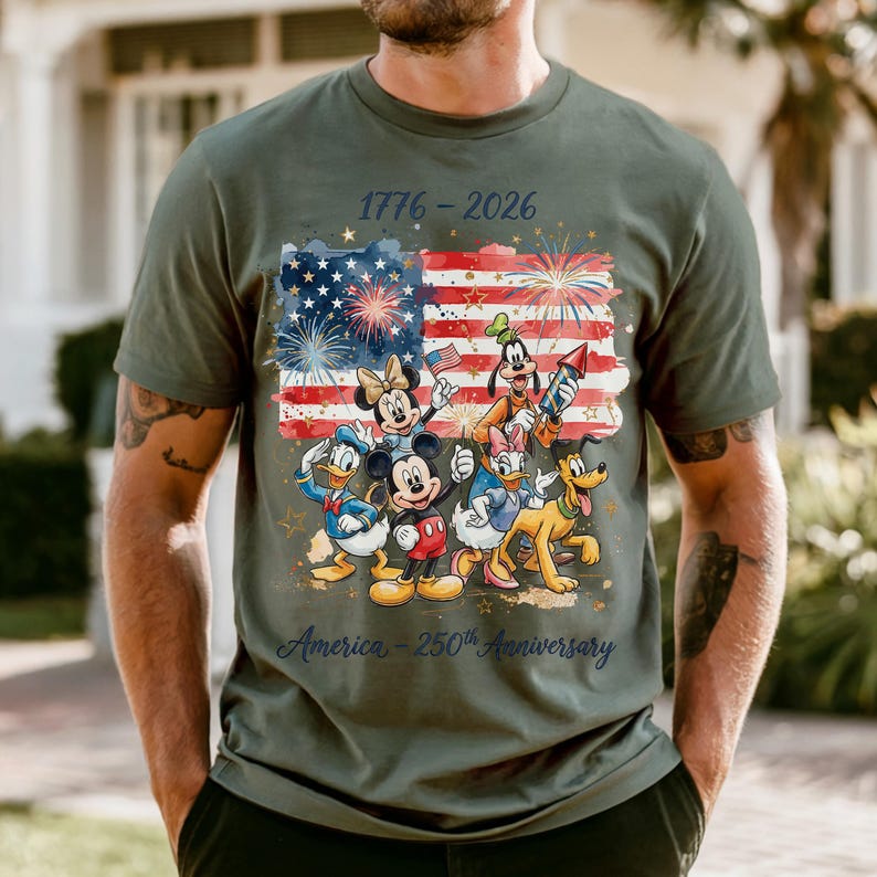 A man wearing a green t-shirt with a graphic design featuring Disney characters and fireworks.