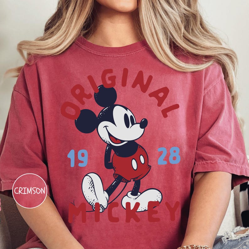 A person wearing a red t-shirt with a graphic of Mickey Mouse and the text "ORIGINAL MICKEY" printed on it.