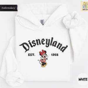 A white hoodie with the text "Disneyland EST. 1955" and a Minnie Mouse graphic printed on it.