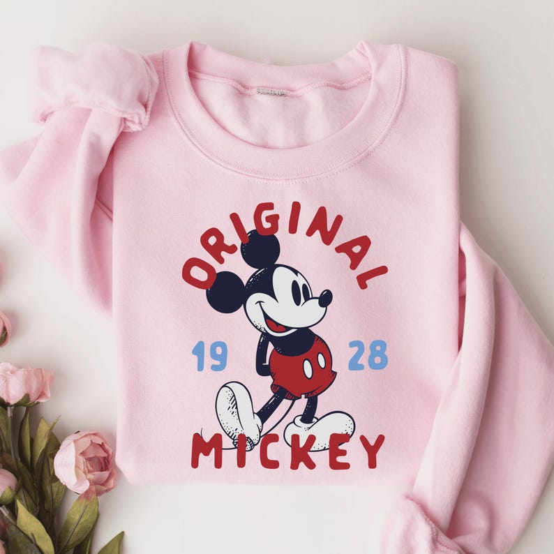 A pink sweatshirt with a Mickey Mouse graphic and the text "ORIGINAL MICKEY" printed on it.