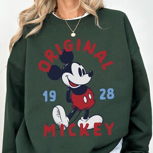 A green sweatshirt with a graphic of Mickey Mouse and the text "ORIGINAL MICKEY" printed on it.