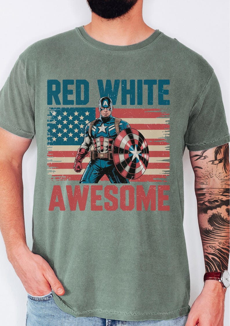 A t-shirt with a graphic design featuring a superhero character, specifically Captain America, holding a shield and the text "RED WHITE AWESOME" above him.