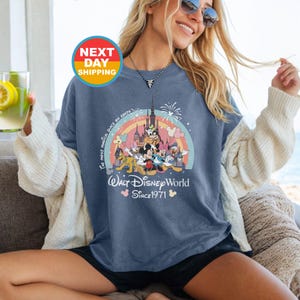 May include: A blue t-shirt with a colorful graphic of Mickey Mouse and friends in front of Cinderella's Castle. The text "The most magical place on Earth" and "Walt Disney World Since 1971" are printed on the shirt.