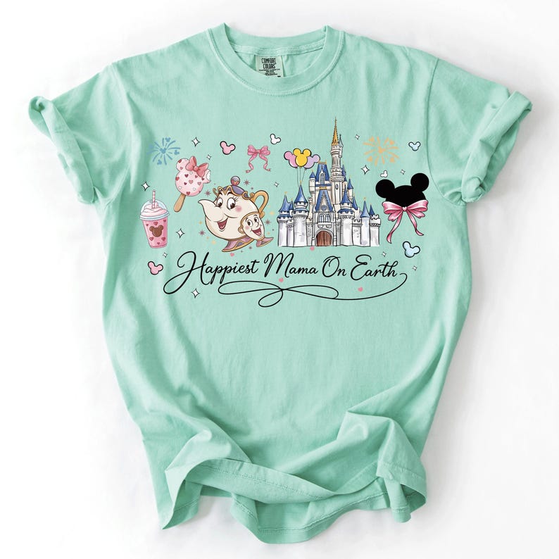 A mint green t-shirt with a Disney-themed design, including a castle, Belle, and various Disney characters. The text on the shirt reads "Happiest Mama On Earth".