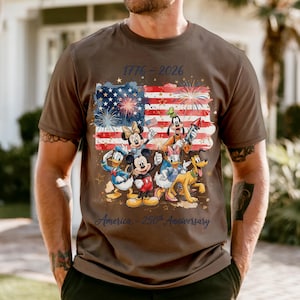 A man wearing a t-shirt with a graphic design featuring Disney characters and fireworks, celebrating the 50th anniversary of the United States.