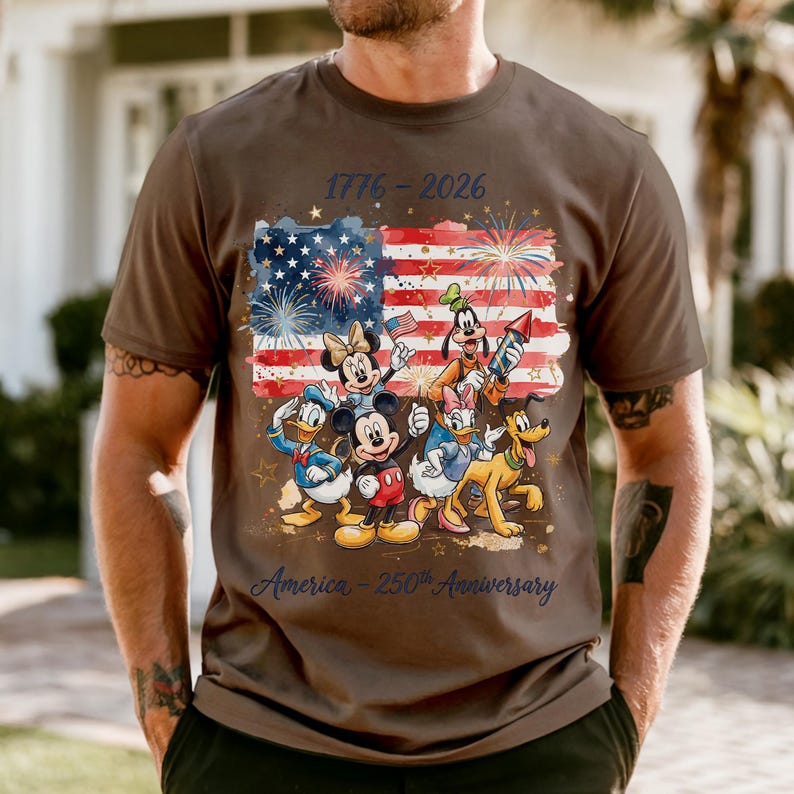 A man wearing a t-shirt with a graphic design featuring Disney characters and fireworks, celebrating the 50th anniversary of the United States.