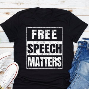 May include: Black t-shirt with a white distressed graphic that says "FREE SPEECH MATTERS".
