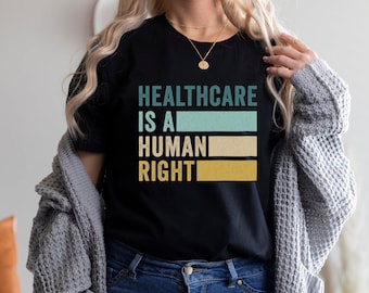 May include: A black t-shirt with the text "Healthcare is a Human Right" in a vintage style font with colorful stripes.