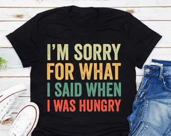 May include: A black t-shirt with a vintage-style graphic that reads "I'm sorry for what I said when I was hungry".