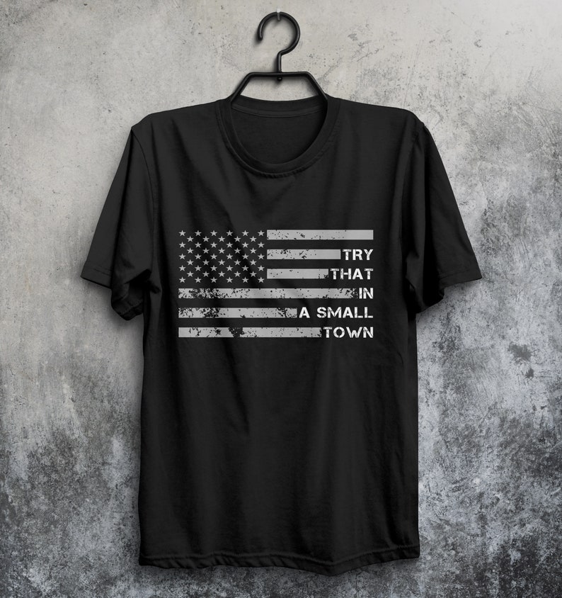 May include: Black t-shirt with a distressed American flag design and the text "TRY THAT IN A SMALL TOWN".