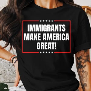 May include: Black t-shirt with a red and white graphic that says "Immigrants Make America Great!"
