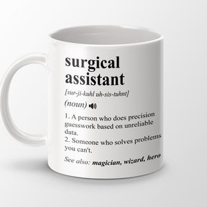 Può includere: Tazza in ceramica bianca con un designo nero che definisce la parola "assistente chirurgico" e la sua pronuncia. La definizione include due punti elenco e la frase "Vedi anche: mago, mago, eroe".