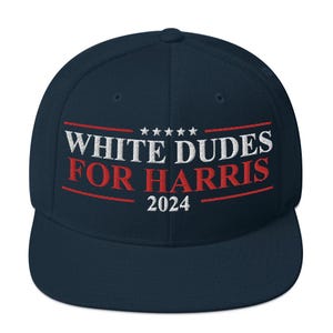 May include: A navy blue baseball cap with a white embroidered slogan that reads "White Dudes For Harris 2024".