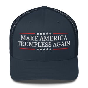Könnte beinhalten: Eine marineblaue Trucker-Kappe mit einem weißen gestickten Slogan "Make America Trumpless Again" mit roten Sternen und Streifen.