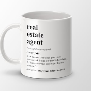 May include: White ceramic mug with a black design that defines a real estate agent as a person who does precision guesswork based on unreliable data and solves problems you can't. The text also includes the phonetic pronunciation of the term and the words "magician, wizard, hero" as synonyms.