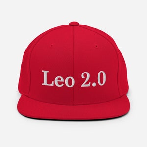 May include: A red and black baseball cap with white embroidery that reads "Leo 2.0".