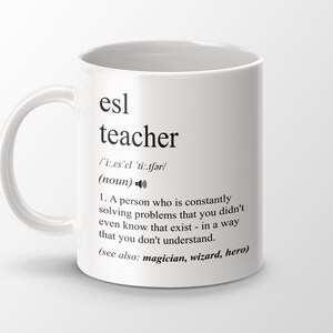 Könnte beinhalten: Weiße Keramiktasse mit einem schwarzen Design, das das Wort "ESL-Lehrer" definiert und eine Definition und einen Ausspracheleitfaden enthält. Die Definition lautet: "Eine Person, die ständig Probleme löst, von denen Sie nicht einmal wussten, dass sie existieren - auf eine Weise, die Sie nicht verstehen. (siehe auch: Zauberer, Zauberer, Held)"