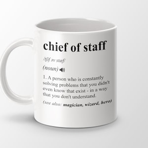 Puede incluir: Taza de cerámica blanca con una definición negra de "jefe de estado mayor" impresa en ella. La definición dice: "Una persona que constantemente resuelve problemas que ni siquiera sabías que existían, de una manera que no entiendes. (ver también: mago, mago, héroe)"