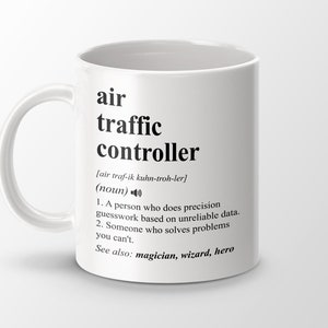 May include: White ceramic mug with a black graphic that reads "air traffic controller" with the phonetic pronunciation and definition. The definition reads "A person who does precision guesswork based on unreliable data. Someone who solves problems you can't. See also: magician, wizard, hero."
