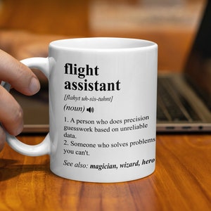 May include: White ceramic mug with a black and white definition of "flight assistant" printed on it. The definition reads: "[flahyt uh-sis-tuhnt] (noun) 1. A person who does precision guesswork based on unreliable data. 2. Someone who solves problems you can't. See also: magician, wizard, hero"