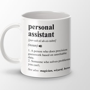 Op de afbeelding: Witte keramische mok met een zwarte definitie van het woord "persoonlijke assistent" met een fonetische uitspraak en een humoristische definitie. De mok heeft een zwart handvat.
