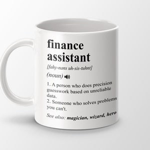 Może przedstawiać: Biały ceramiczny kubek z czarnym nadrukiem, na którym widnieje napis "finance assistant" wraz z definicją i słowami "magik, czarodziej, bohater".