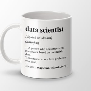 May include: White ceramic mug with a black design that defines a data scientist as a person who does precision guesswork based on unreliable data. The mug also says "See also: magician, wizard, hero".