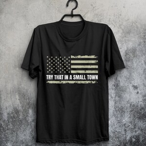 May include: Black t-shirt with a distressed American flag design and the text "TRY THAT IN A SMALL TOWN".