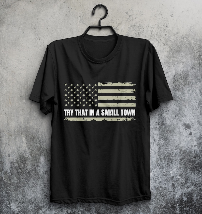 May include: Black t-shirt with a distressed American flag design and the text "TRY THAT IN A SMALL TOWN".