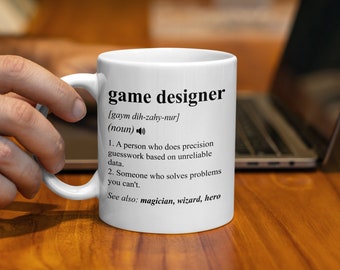 May include: White ceramic mug with a black design that reads "game designer" and defines the term as "a person who does precision guesswork based on unreliable data." The definition also includes "See also: magician, wizard, hero."