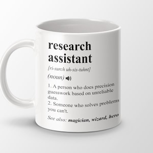May include: White ceramic mug with a black design that reads "research assistant" and defines the term as "a person who does precision guesswork based on unreliable data" and "someone who solves problems you can't". The mug also says "See also: magician, wizard, hero".
