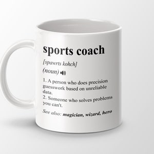 May include: White ceramic mug with a black design that defines the word "sports coach" and includes a phonetic pronunciation, definition, and related terms. The text reads: "sports coach [spawrts kohch] (noun) 1. A person who does precision guesswork based on unreliable data. 2. Someone who solves problems you can't. See also: magician, wizard, hero"