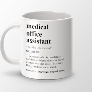 Op de afbeelding: Een witte keramische mok met een zwart ontwerp met de tekst "medical office assistant" en een definitie van de term. De definitie luidt: "/'medikəl 'ǝfıs a'sıstənt/ (zelfstandig naamwoord) 1. Een persoon die voortdurend problemen oplost waarvan je niet eens wist dat ze bestonden - op een manier die je niet begrijpt. (zie ook: tovenaar, tovenaar, held)"