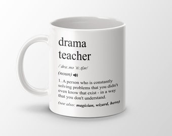 Może przedstawiać: Biały kubek ceramiczny z czarnym nadrukiem, na którym widnieje napis "nauczyciel dramatu" oraz definicja tego słowa. Definicja zawiera wymowę, część mowy i humorystyczny opis zawodu.