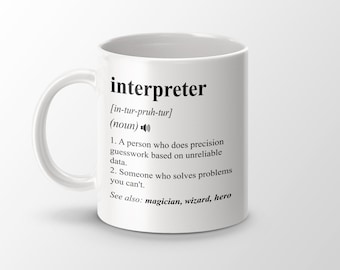 Könnte beinhalten: Weiße Keramiktasse mit einem schwarzen Design, das das Wort "Dolmetscher" und seine Aussprache definiert. Die Definition enthält eine humorvolle Beschreibung der Rolle eines Dolmetschers.