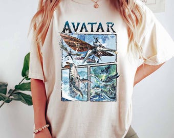 Może przedstawiać: Kremowa koszulka z napisem "AVATAR" nad czteropanelową grafiką. Grafika przedstawia sceny z filmu, w tym latające stworzenie i zwierzęta wodne. Koszulka jest w wygodnym, swobodnym stylu.