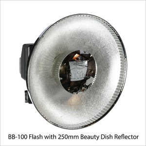 May include: A silver beauty dish reflector for a flash unit. The reflector is 250mm in diameter and has a black Triflec logo on the front.