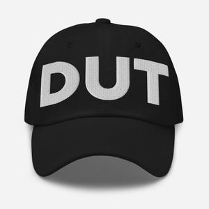 May include: A black baseball cap with the word "DUT" embroidered in white on the front.